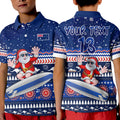 custom-text-and-number-australia-christmas-polo-shirt-kid-aussie-aboriginal-santa-claus-is-surfing-with-kangaroo